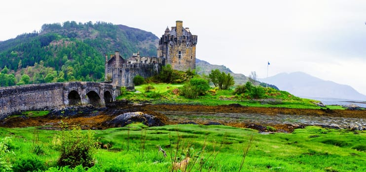 Panoramic view of famous Eilean Donan Castle in Scotland, UK. Situated on a small isle at the meeting point of three sea lochs - Loch Long, Loch Duich and Loch Alsh, is one of the most iconic images of Scotland.