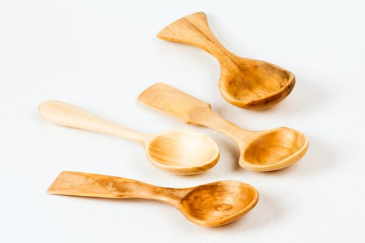 Four unique wooden spoons are on white background, wood carving concept.