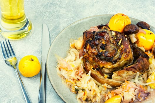 Roasted knuckle of pork with cabbage and beer. Traditional German recipe.