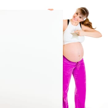 Smiling beautiful pregnant woman  pointing finger at blank billboard  isolated on white.
