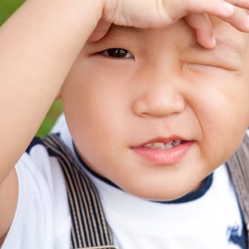 Little Asian boy is confusing, close up face.