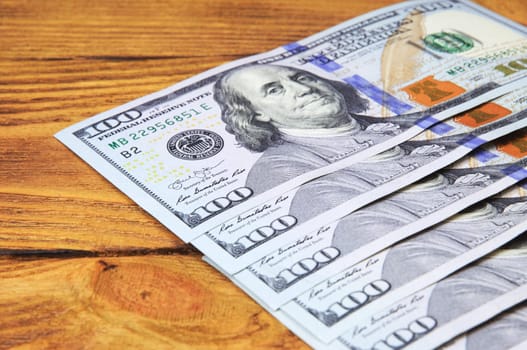 Dollars in a row diagonally on wooden boards.
