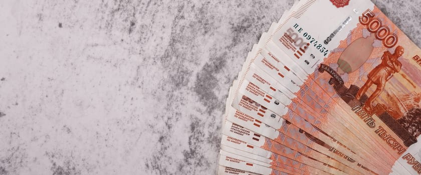 Russian money banknotes of five thousand rubles, background, banknotes are arranged in a fan on a gray background. Layout, mockup.