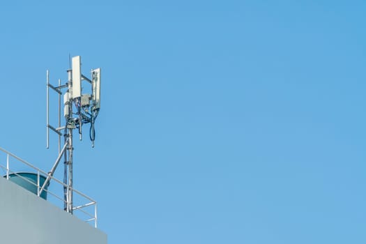 Cellular phone towers are on the rooftop of the building.