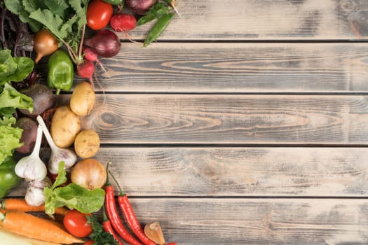 Colorful tasty homegrown food composition of variety of healthy organic farm vegetables on wooden background. Grocery, food market and store. Health care and farm growth produce. Copy space, top view