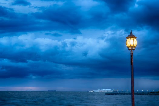 Light Post at nigth near sea with stom background