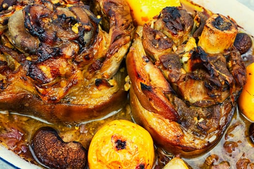 Traditional pork knuckle cooked in dark beer, sauerkraut and apples. German recipe.