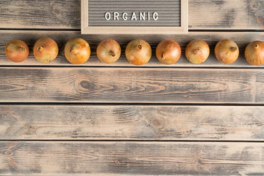 Food composition of onion bulbs, chilly pepper, apples and tomatoes, potato on shelves with name board organic. Organic food and fresh vitamin meal in market, store. Top view, flat lay, copy space