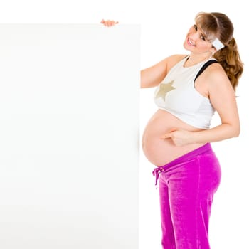 Smiling beautiful pregnant woman  pointing finger at blank billboard  isolated on white.