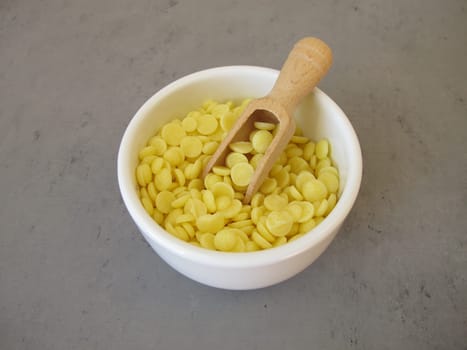 A bowl of light yellow cocoa butter chips as an ingredient for cooking and baking, chocolate making or personal care products