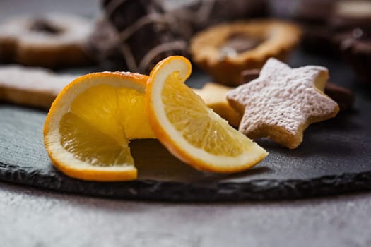 Tasty homemade Christmas cookies on black plate, closeup view