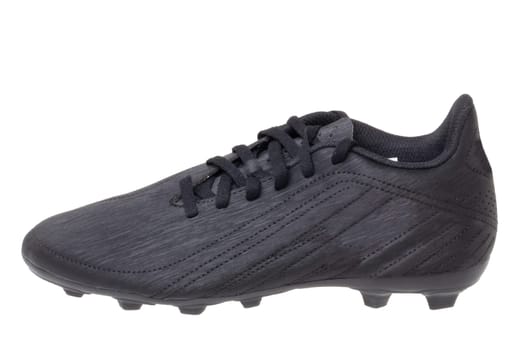 Closeup of a single black leather football boot isolated on white background. Professional athletics boys outdoor training shoes. Sports shoes.