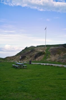 Hundested, Denmark picnic place in front of the cliffs. Flagpole with the Danish flag on the hill. Landscape photo from Scandinavia