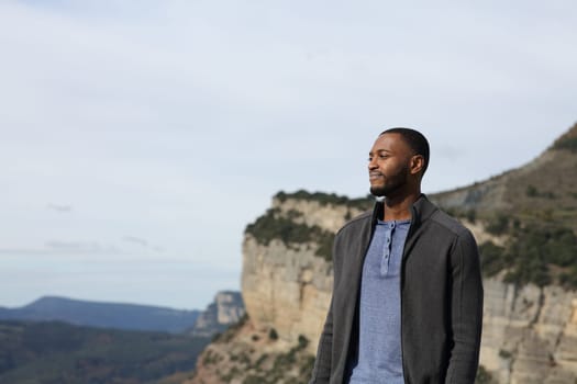Confident black man contemplating views in the mountain