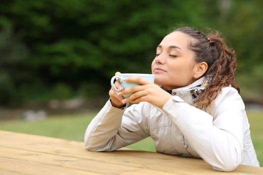 Hiker sitting in a camping drinking coffee and relaxing