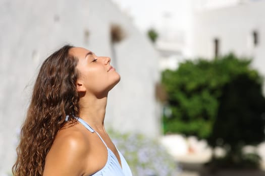 Side view portrait of a woman on summer breathing fresh air in a town