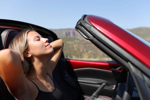 Relaxed driver resting in a convertible car