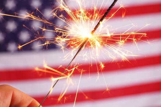 sparkler and usa flag showing 4th of july