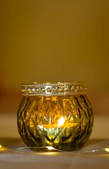 A lantern with a tea light atmospherically illuminates a table in the evening.