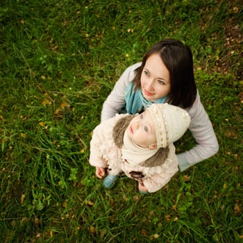 Mother and daughter on a walk looking at the sky while sitting on the grass