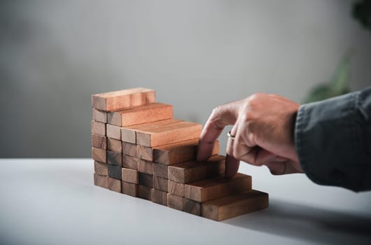 Business two finger symbol walking up on wood blocks shape staircase to climb up career ladder step up stair growth success, prevent collapse or crash concept