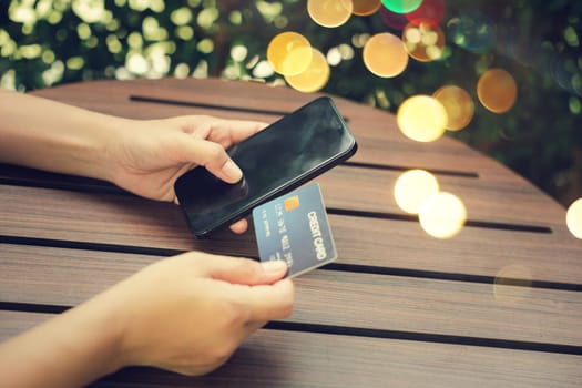 Close up hand of woman using credit card and smartphone during slide screen for finding product purchase buying payments online shopping, making secure internet payment browsing banking service