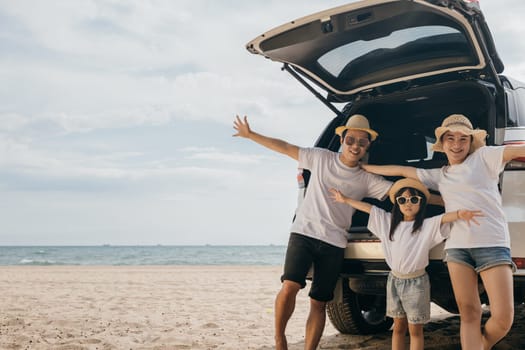 Happy Family Day. People enjoying road trip standing on back their car raise arms and hand up, Father, Mother and daughter traveling at sea beach, small family having fun in summer vacation on beach