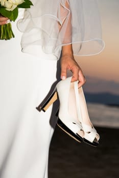 View held by the bridal shoes bride with sunset in background