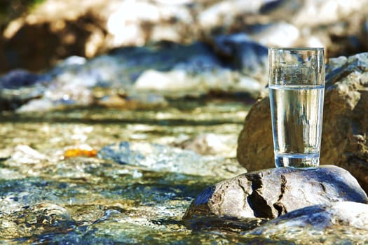 Water glass by a stream