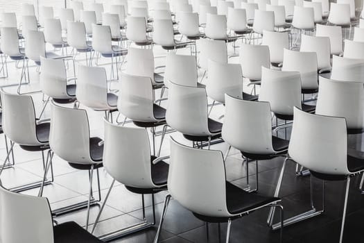 Interior of empty contemporary conference hall with white chairs.