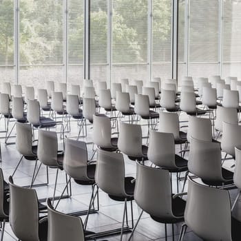 Interior of empty contemporary conference hall with white chairs.