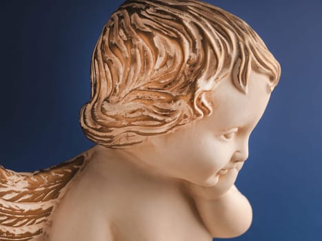 Close up of an angel with golden hair on a blue background, Christmas time