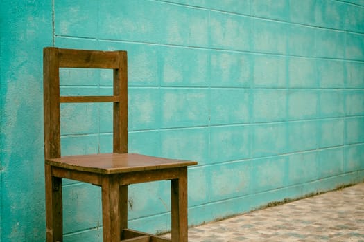Wooden chair with blue concrete wall