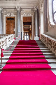 Turin, Italy - Circa January 2022: red carpet in Royal Palace - luxury elegant marble stairway