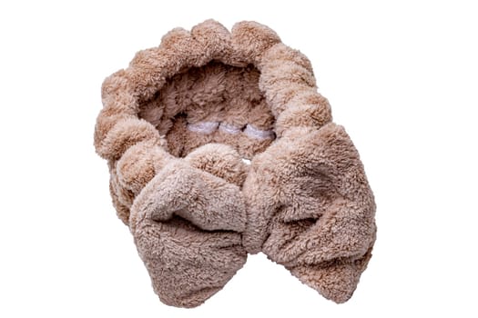 Brown hair band with bow made of high quality coral fleece which is super soft and skin friendly. Hairband for face wash, make-up, shower, skin and beauty care for ladies and girls isolated.