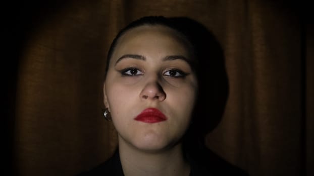 Fashion close-up portrait of model female with make-up. stressed face, depression. Dark background. Flashing light, strobe. Abuse, violence concept.