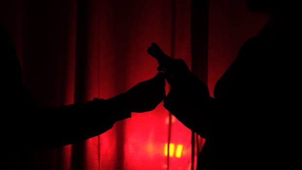 silhouette of Young woman rejecting marriage proposal on dark red background throw the ring in man. Rejecting marriage concept. Refusal of marriage