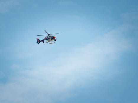 Police helicopter in flight speeding against the blue sky