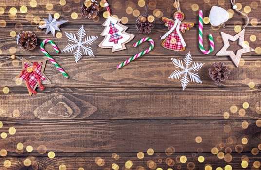 Beautiful Christmas composition on wood background with Christmas conifer cones, holiday decoration, caramel stick. Top view, copy space.
