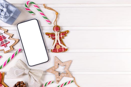 Smartphone mock up with rustic Christmas decorations on withe wood table for app presentation. View from above