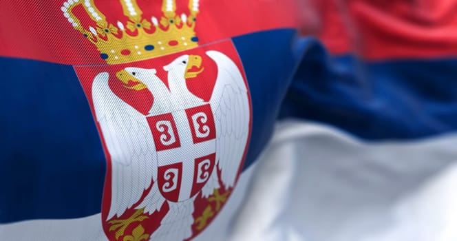 Close-up view of the Serbia national flag waving in the wind. The Republic of Serbia is a State of Southeast Europe. Fabric textured background. Selective focus. 3d illustration