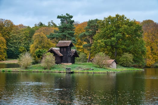 Frederiksborg castle park lake with island on which the wood Louises stands. Walk in Denmark