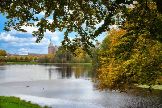 Frederiksborg castle park with created lake, in the background the castle. Bright colors of the leaves. Walk in Denmark