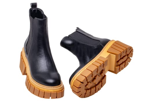Ladies Chelsea boots. Close-up of a pair womens black leather chelsea boots with high heels isolated on a white background. Macro. Fashion advertisment shoes.