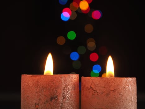 Two Advent candles burning with Christmas lights bokeh and space for text
