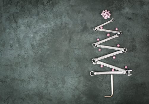 Christmas tree made with wrenches and baubels, new year greeting card with repair tools, dark background