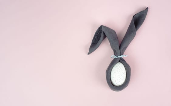 Easter bunny, wrapped egg with a cloth, minimal spring holiday concept