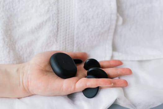 Plump woman getting hot stones arm massage in a spa salon. Therapy, wellness and relaxation concept