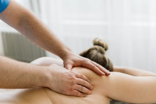 Young fat woman getting massage treatment in a day spa cabinet.