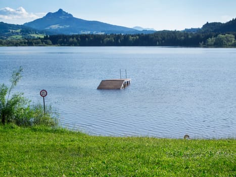Landscape view with a view of the first foothills of the Alps at Grüntensee during flooding after heavy downpour in Bavaria.
